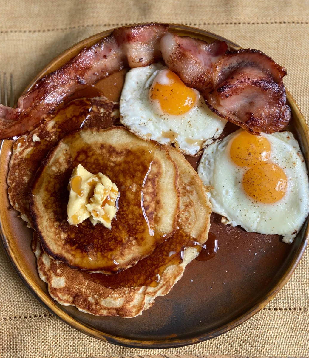 El Gringo: Dos pancakes, dos tiras de tocino, dos huevos, 3 frutas a elegir y jarabe de maple.
