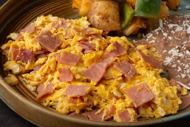 Huevos al Gusto: 3 huevos revueltos, estrellados o a la mexicana. Extra de proteína disponible.
