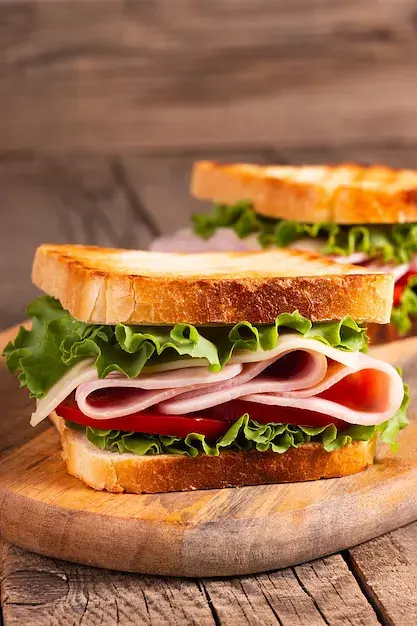 Sándwich: Brioche de masa madre con lechuga, cebolla caramelizada y tocino. Elige proteína y aderezo.
