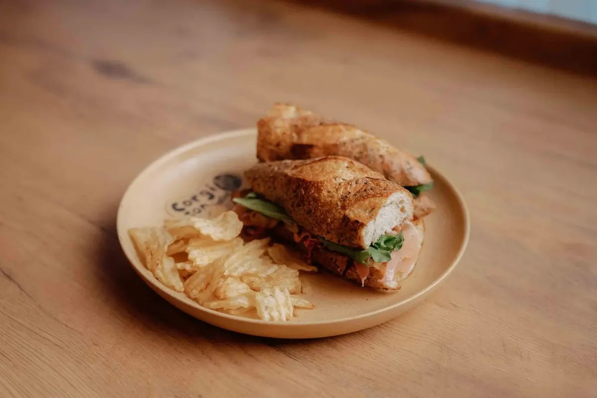 Baguette: Lechuga, cebolla caramelizada y tocino. Elige proteína y aderezo.
